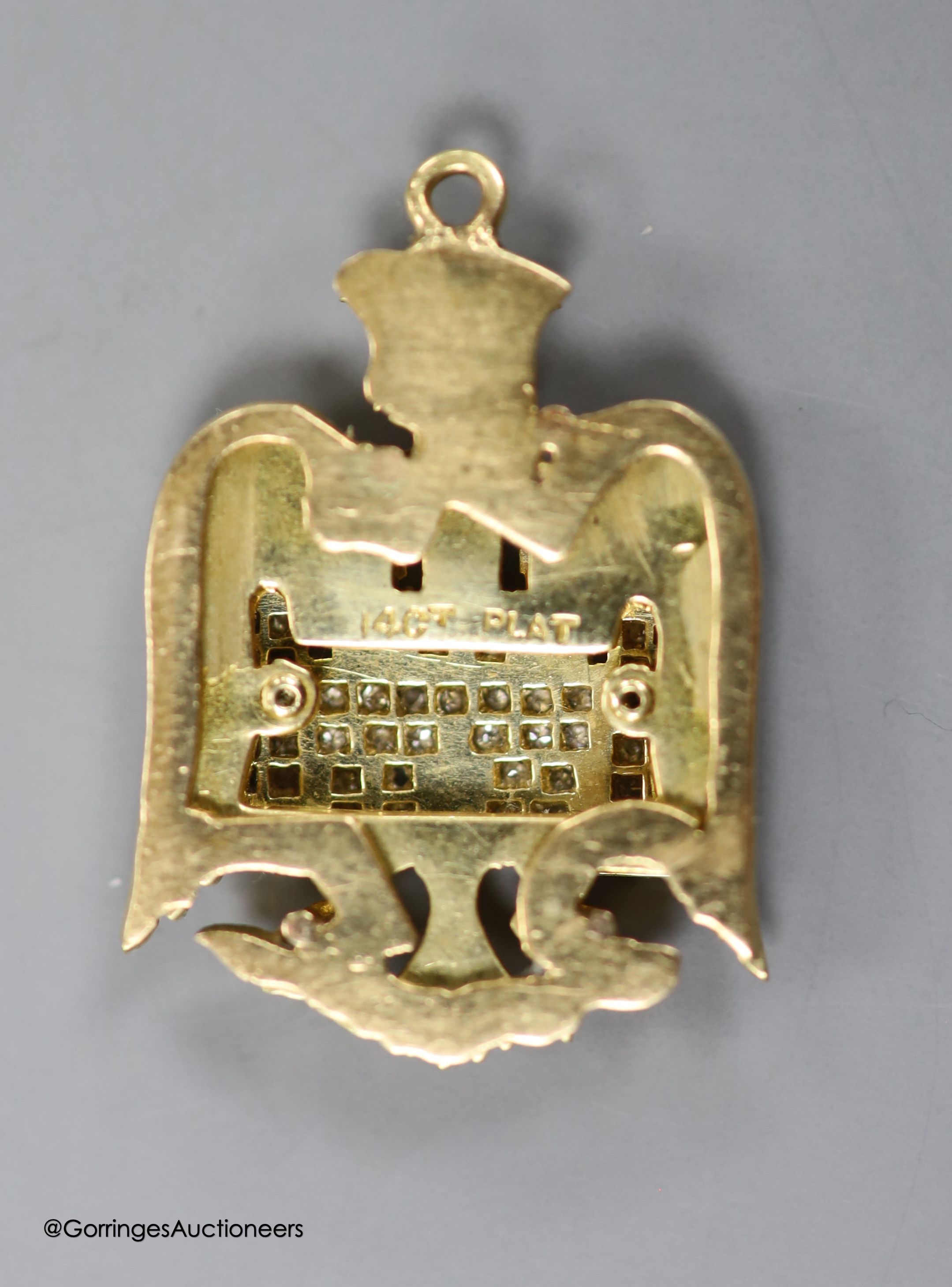 A 14ct, plat and diamond chip set 'eagle and castle' pendant, 27mm, gross weight 7.2 grams.